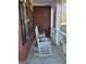 Cozy front porch features two rocking chairs, brick siding, and decorative trim at 5725 Lake Windsor Pkwy, Buford, GA 30518