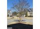 View of the front yard showing a tree and street view of neighborhood houses at 5725 Lake Windsor Pkwy, Buford, GA 30518