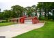 Exterior of red home with spacious driveway, and attached garage surrounded by lush trees at 125 Point View Ct, Tyrone, GA 30290