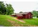 View of home's exterior featuring a red facade, shed, covered bench, and green lawn at 125 Point View Ct, Tyrone, GA 30290