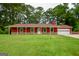 Charming red home with a covered porch, stone accents, and a well-manicured lawn surrounded by mature trees at 125 Point View Ct, Tyrone, GA 30290