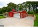 Exterior shot showcasing the red house, the expansive concrete driveway, and the multi-car garage at 125 Point View Ct, Tyrone, GA 30290