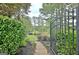 Picturesque backyard featuring lush greenery, mature trees, and a gated entrance at 383 Beaumont Farms Dr, Sharpsburg, GA 30277