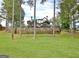 A backyard view shows a tiered stone retaining wall, fenced yard, and back of the home at 383 Beaumont Farms Dr, Sharpsburg, GA 30277