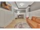 Cozy basement living room featuring an tan leather sofa, tv, light wood floors, and stylish decor at 383 Beaumont Farms Dr, Sharpsburg, GA 30277