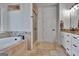 Bright bathroom featuring travertine tile, walk-in shower, soaking tub and double vanity sinks at 383 Beaumont Farms Dr, Sharpsburg, GA 30277