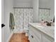 Clean bathroom featuring granite countertops, neutral tile floors, and decorative shower curtain at 383 Beaumont Farms Dr, Sharpsburg, GA 30277