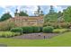 Beaumont Farms entrance with stone pillars, brick wall, lush landscaping, and a well-maintained lawn at 383 Beaumont Farms Dr, Sharpsburg, GA 30277