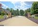 Elegant gated entrance to a private property with stone pillars and manicured landscaping at 383 Beaumont Farms Dr, Sharpsburg, GA 30277