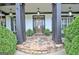 Inviting front porch with stone flooring, ferns, hanging pendant lighting, and black trim at 383 Beaumont Farms Dr, Sharpsburg, GA 30277