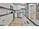 Bright kitchen featuring white cabinets, granite counters, stainless steel appliances, and modern fixtures at 383 Beaumont Farms Dr, Sharpsburg, GA 30277