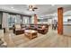 Open living room with hardwood floors, large leather sofa, and view into the kitchen at 383 Beaumont Farms Dr, Sharpsburg, GA 30277