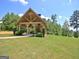 A charming covered outdoor pavilion features a stone fireplace overlooking green lawns at 383 Beaumont Farms Dr, Sharpsburg, GA 30277
