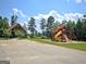 Community playground with a play structure featuring a slide and swings for outdoor recreation at 383 Beaumont Farms Dr, Sharpsburg, GA 30277