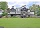 Rear exterior view showcasing a multi-level deck, screened porch, and a spacious lawn at 383 Beaumont Farms Dr, Sharpsburg, GA 30277