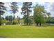 Scenic waterfront view with lush green lawn and trees, perfect for a relaxing and picturesque setting at 383 Beaumont Farms Dr, Sharpsburg, GA 30277