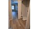 Hallway offers a view into the laundry room with luxury vinyl flooring, neutral paint and white trim at 1601 Celestial Ct, Mcdonough, GA 30253