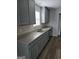 Kitchen featuring grey cabinets, stainless steel double sink, light countertops and luxury vinyl flooring at 1601 Celestial Ct, Mcdonough, GA 30253