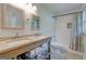 Bathroom with double sinks, wood vanity, storage baskets and a tub/shower combo at 1848 Winthrop Se Dr, Atlanta, GA 30316