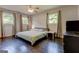 Bright bedroom with three windows, ceiling fan, and dark wood flooring at 1848 Winthrop Se Dr, Atlanta, GA 30316