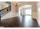 Open-concept living space featuring hardwood floors, chandelier, and elegant archway at 335 Autumn Bluff Dr, Lawrenceville, GA 30044