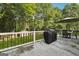 Back patio featuring grill and dining set, perfect for outdoor relaxation and entertaining, with views of mature trees at 905 Creekmore Ln, Loganville, GA 30052
