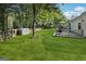 Spacious backyard featuring a storage shed, a patio with grilling area, and lush lawn surrounded by mature trees at 905 Creekmore Ln, Loganville, GA 30052