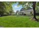 Expansive backyard features a patio with dining, surrounded by lush lawn and mature trees providing a serene outdoor space at 905 Creekmore Ln, Loganville, GA 30052
