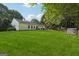 Spacious backyard with a well-manicured lawn, featuring a patio with dining furniture and surrounded by mature trees at 905 Creekmore Ln, Loganville, GA 30052