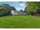 Expansive backyard with a lush lawn, a patio area perfect for entertaining, and mature trees bordering the property at 905 Creekmore Ln, Loganville, GA 30052