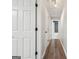 Hallway with wood floors leading to a bathroom and other rooms, with white doors and black hardware at 905 Creekmore Ln, Loganville, GA 30052