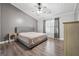 The main bedroom featuring wood floor, ceiling fan, side tables, a comfortable bed, and plenty of natural light at 905 Creekmore Ln, Loganville, GA 30052