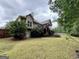 The backyard is framed by mature trees and features a home with a screened porch, offering serene outdoor space at 237 Shockley Way, Dallas, GA 30157