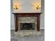 A stone fireplace with a decorative mantel is flanked by sconces and trimmed with wood at 237 Shockley Way, Dallas, GA 30157