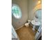 Charming powder room boasts pedestal sink, tiled floors, and an oval window at 237 Shockley Way, Dallas, GA 30157