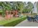 Grassy backyard with play equipment, a patio, and surrounding trees at 4180 Pineset Dr, Alpharetta, GA 30022