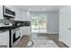 Bright kitchen with stainless steel appliances, white cabinets, and sliding glass doors leading to backyard at 4180 Pineset Dr, Alpharetta, GA 30022