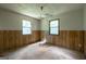Bedroom featuring two windows and wood paneling along the lower wall area at 400 Mccart Rd, Mcdonough, GA 30252