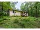 Exterior of home featuring a small porch and windows, surrounded by a wooded area at 400 Mccart Rd, Mcdonough, GA 30252