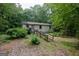 Single-story home exterior featuring a ramp, surrounded by wooded landscape at 400 Mccart Rd, Mcdonough, GA 30252