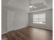 Spacious bedroom featuring tray ceiling, ceiling fan, window with blinds, and hardwood floors at 424 Browning Field Way, Hampton, GA 30228