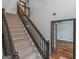 Carpeted staircase features a dark wooden handrail and decorative spindles leading to the upper level at 424 Browning Field Way, Hampton, GA 30228
