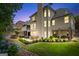 An expansive backyard featuring a patio, garden beds, and lush green lawn at dusk at 5833 Wembley Dr, Douglasville, GA 30135