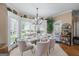 Sun-drenched dining area with a glass-top table, lush plants, and large bay windows at 5833 Wembley Dr, Douglasville, GA 30135