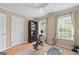 Bright exercise room featuring hardwood flooring, a ceiling fan, two windows, and fitness equipment at 5833 Wembley Dr, Douglasville, GA 30135