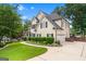 Side view of well-maintained home, 2-car garage, long driveway, and green lawn at 5833 Wembley Dr, Douglasville, GA 30135
