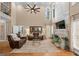Bright living room with two-story ceilings, modern fan, decorative fireplace, and two brown leather couches at 5833 Wembley Dr, Douglasville, GA 30135