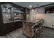 Stylish bar with stone accents, custom cabinets, mini-fridge and seating for three at 6248 Sunshine Cove Ln, Buford, GA 30518