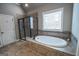 Beautiful bathroom featuring a shower with glass doors, tub and large windows at 6248 Sunshine Cove Ln, Buford, GA 30518