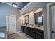 Double sink bathroom with dark cabinets, tile floors, framed mirrors and granite countertops at 6248 Sunshine Cove Ln, Buford, GA 30518